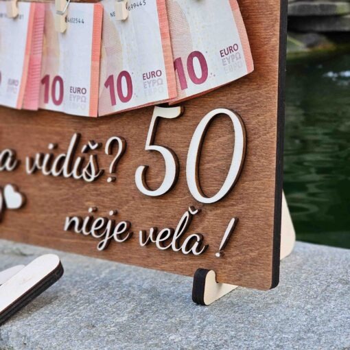 Tmavá drevená narodeninová tabuľka na darovanie peňazí so špagátom a štipcami na pripnutie peňazí.